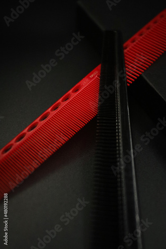 two flat combs from a professional hairdressing set lie on a black background