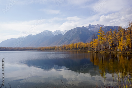 Mountain lake in the taiga and Kodar ridge