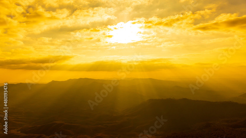 Landscape photo of sunset over clouds with mountain hill forest. in golden light tone. © Phongsak