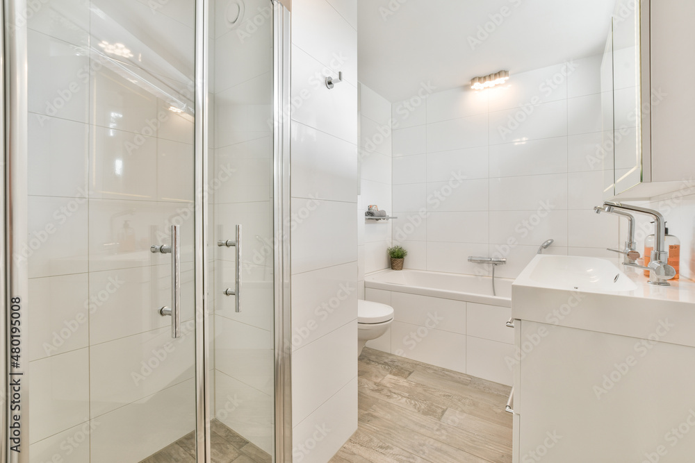 Interior of modern white bathroom with tub and shower cabin Interior of modern white bathroom with tub and shower cabin