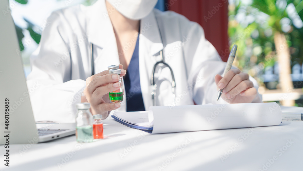 Woman Doctor wearing a face shield and PPE suit for Coronavirus outbreak holding showing Covid-19 vaccine at laboratory room, Concept of Covid-19 quarantine. healthcare concept in hospital.