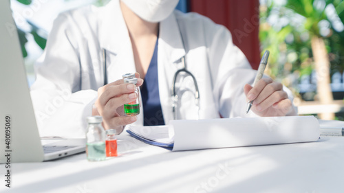 Obraz na płótnie Woman Doctor wearing a face shield and PPE suit for Coronavirus outbreak holding showing Covid-19 vaccine at laboratory room, Concept of Covid-19 quarantine. healthcare concept in hospital. w salonie