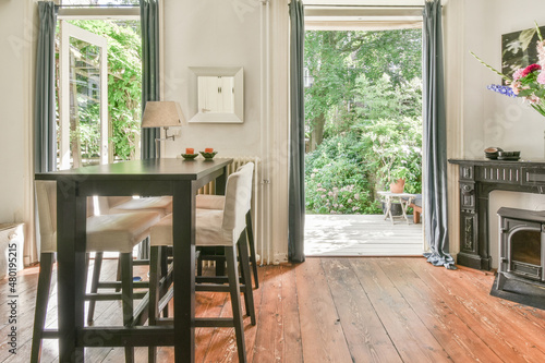 Interior of cozy dining room in cottage viewed to backyard photo