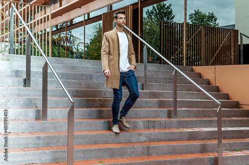 elegant and modern man walking down stairs of important building with positive attitude