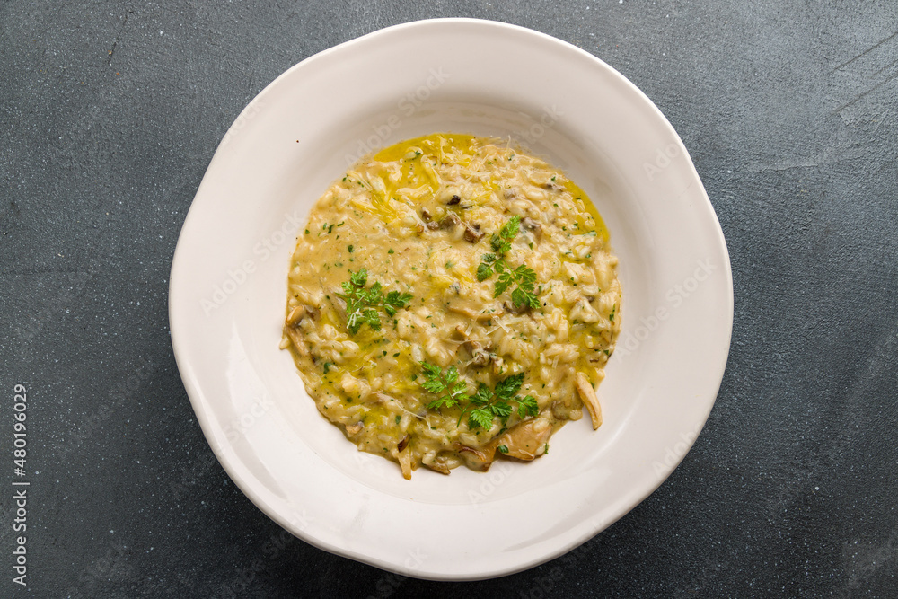 risotto with porcini mushrooms on grey concrete table top view risotto with porcini mushrooms on grey concrete table top view