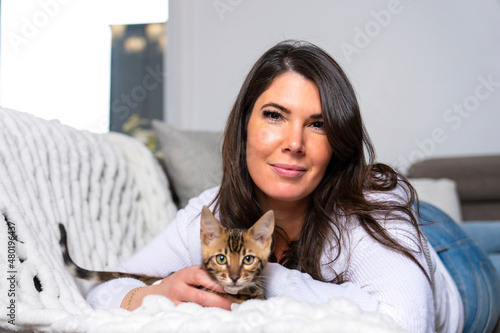 Bengal Cat in the living room on the couch with a woman photo