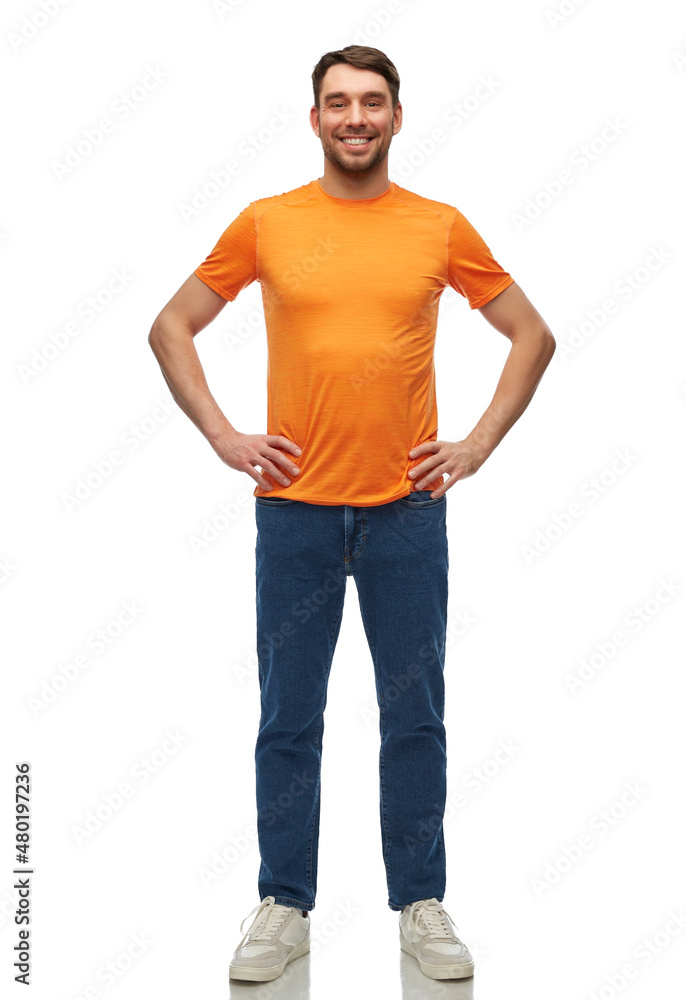 people, fashion and clothes concept - happy smiling man in orange t-shirt and jeans with hands on hips over white background people, fashion and clothes concept - happy smiling man in orange t-shirt and jeans with hands on hips over white background