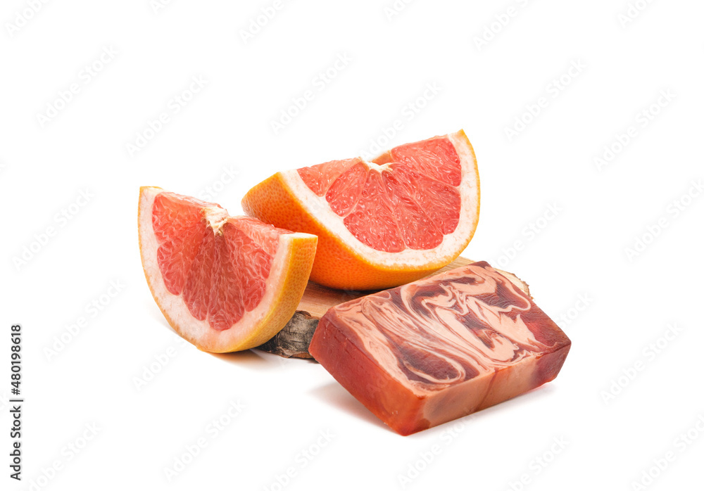Grapefruit slices and a bar of red natural soap on a white background. Isolated. Natural cosmetics concept