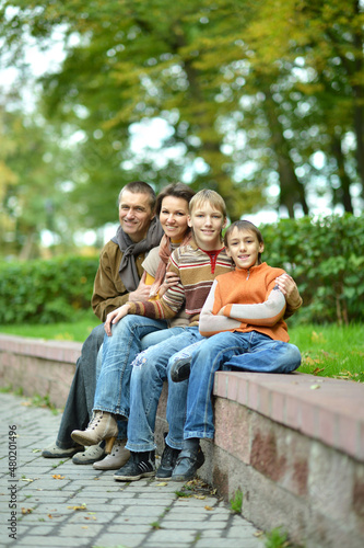 Portrait of family of four sitting in park