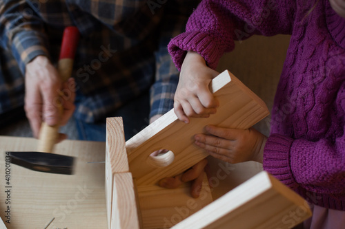 Making a wooden bird feeder. Dad and daughter are doing together. The concept of spending time together. Bird care