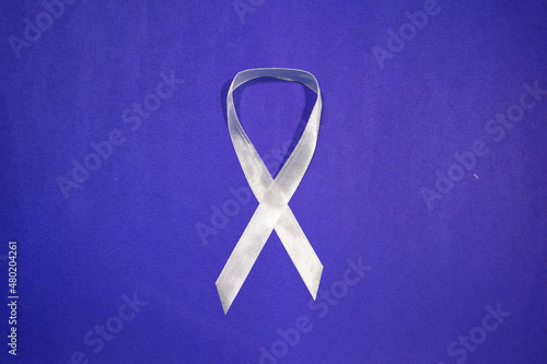 White Ribbon Campaign, of men and boys working to end male violence against women and girls, white ribbon on blue background with copy space
