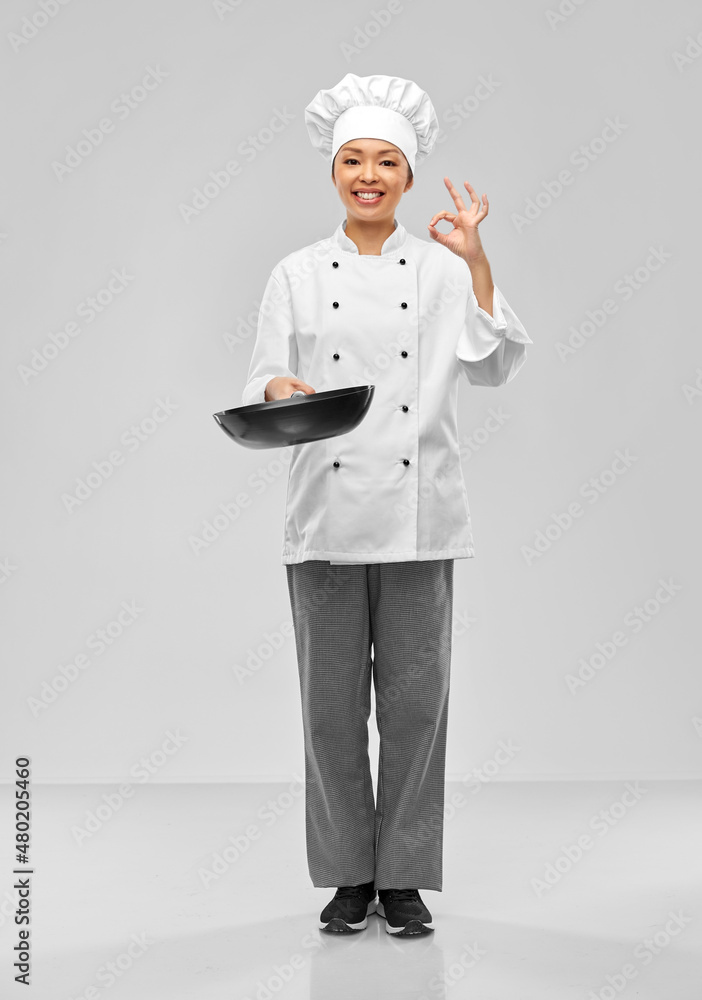 cooking, culinary and people concept - happy smiling female chef with frying pan showing ok gesture over grey background cooking, culinary and people concept - happy smiling female chef with frying pan showing ok gesture over grey background