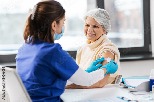 Obraz na płótnie medicine, health and vaccination concept - doctor or nurse applying medical patc