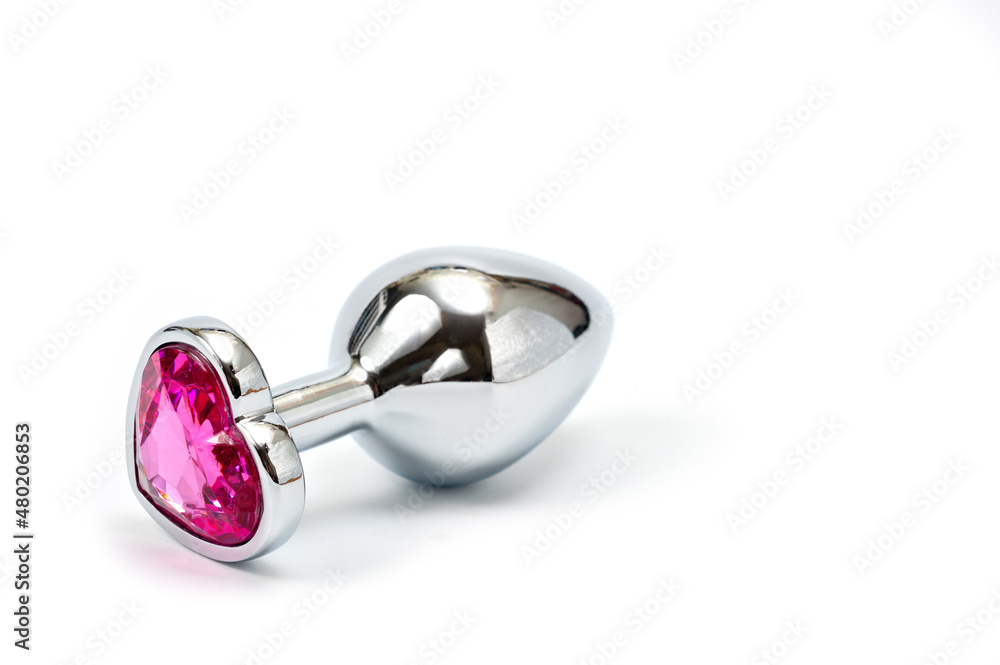 Metal butt plug with a decorative pink heart-shaped stone at the end. Metal butt plug with a decorative pink heart-shaped stone at the end.
