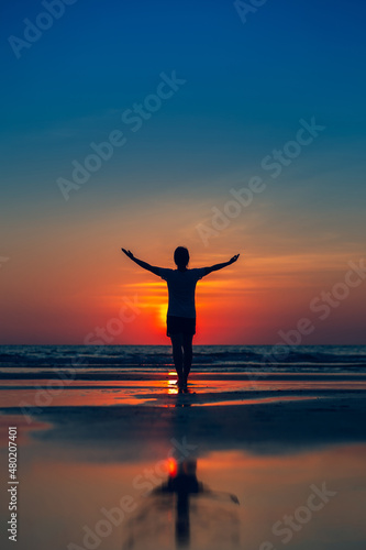 Happy women raise their hands Concept of worshiping god On a blurred ocean and sky background silhouette style vertical