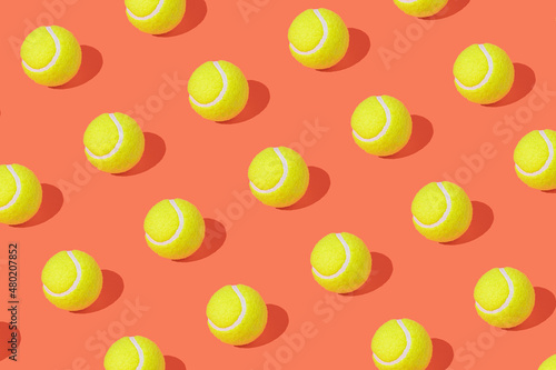 Tennis balls on pastel orange background. Minimal tennis pattern. Champion mood. Green balls pattern. Tennis tournament.