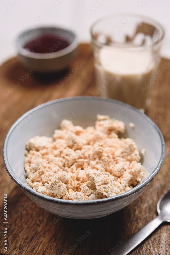 Homemade melted cheese curd served with baked milk and jam on wooden cutboard. Healthy breakfast. Haze effect. Selective focus Homemade melted cheese curd served with baked milk and jam on wooden cutboard. Healthy breakfast. Haze effect. Selective focus
