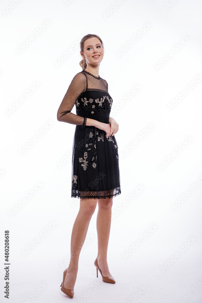High fashion photo of a beautiful elegant young woman in a pretty black dress with lace posing on white background. Studio shot. Slim figure, hair is gathered in a ponytail High fashion photo of a beautiful elegant young woman in a pretty black dress with lace posing on white background. Studio shot. Slim figure, hair is gathered in a ponytail