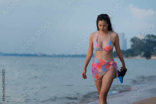 Beautiful Asian woman in two piece Swimwear  work on beach.