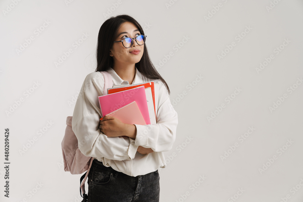 Fototapeta premium Young asian woman in eyeglasses posing with exercise books
