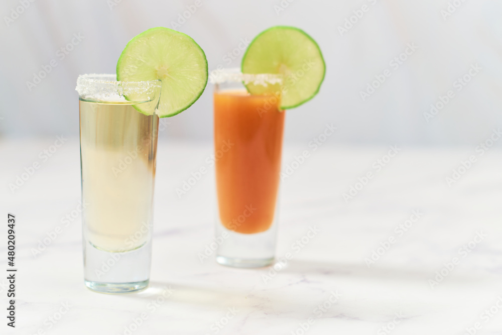Fototapeta premium Tequila shot with sangrita and tequila shot. Mexican appetizer for tequila.