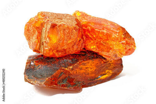 Pieces of red-yellow amber on a white background. Sun stone with inclusions. Natural fossilized resin. Copal. Semi-precious mineral. Material for jewelry and ornaments. Crystal. Amber resin 