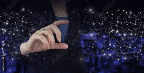 Business network communication and innovation technology concept. Mockup hand with digital hologram datd wave sign on city dark blurred background. Big data visualization futuristic technology.