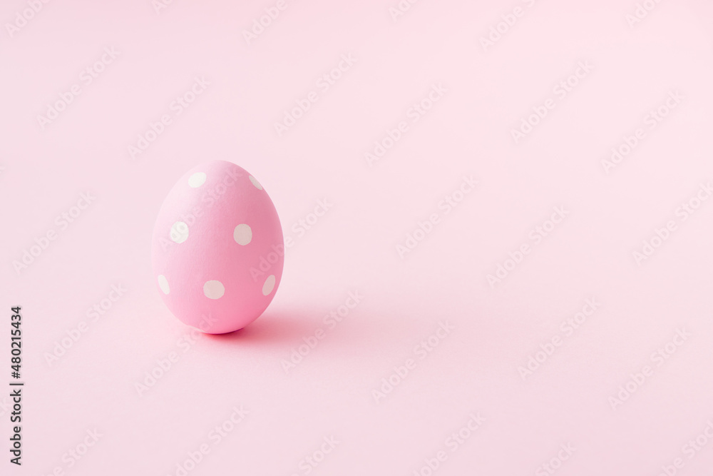 Egg with white dots on pastel pink background. Easter minimal concept. Flat lay mood. Easter egg minimalism. Organic food concept. Holiday seasson.