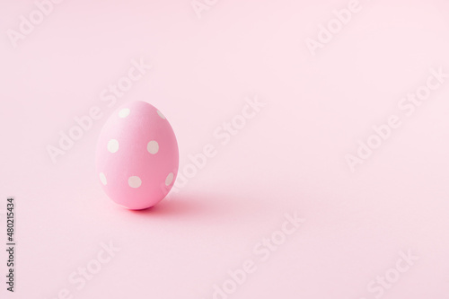 Egg with white dots on pastel pink background. Easter minimal concept. Flat lay mood. Easter egg minimalism. Organic food concept. Holiday seasson.