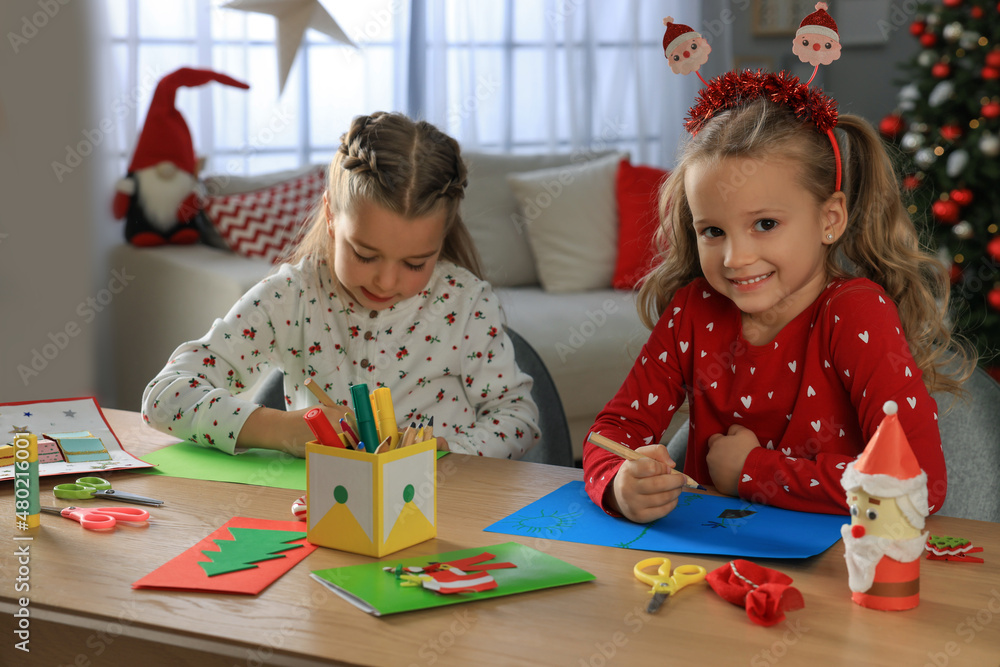 Fototapeta premium Cute little children making beautiful Christmas greeting cards at home