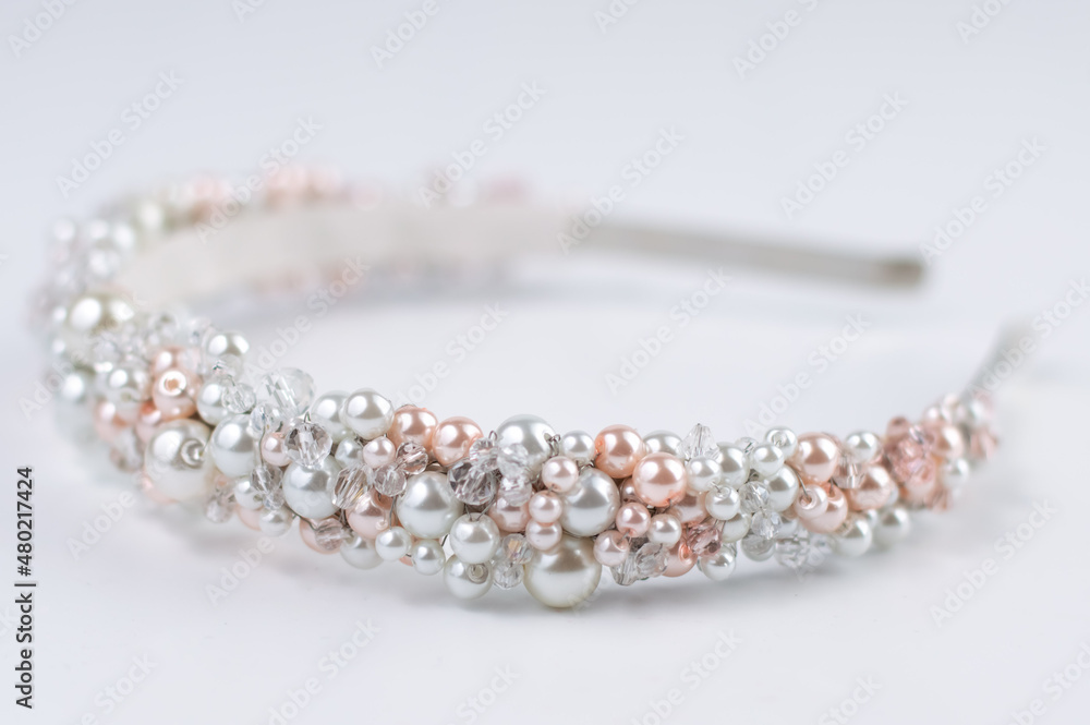 Blurred image of a hairband with white and pink pearls on a light background. Blurred image of a hairband with white and pink pearls on a light background.