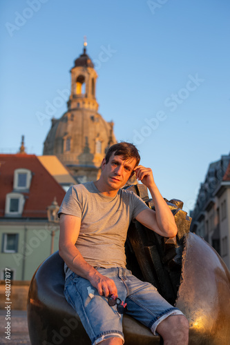 person sitting on a sculpture in the city