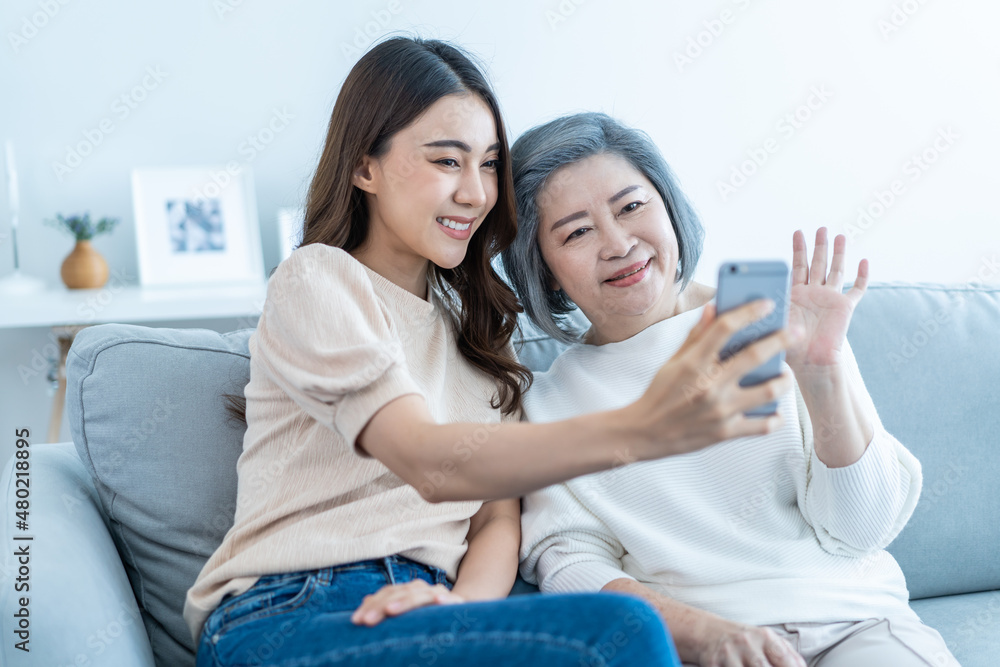 Asian happy family, senior mom use mobile phone with daughter at home. Asian happy family, senior mom use mobile phone with daughter at home.