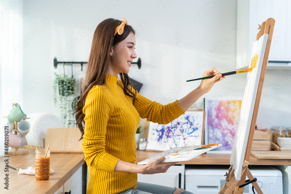 Asian young talented woman artist coloring on painting board in house. Asian young talented woman artist coloring on painting board in house.