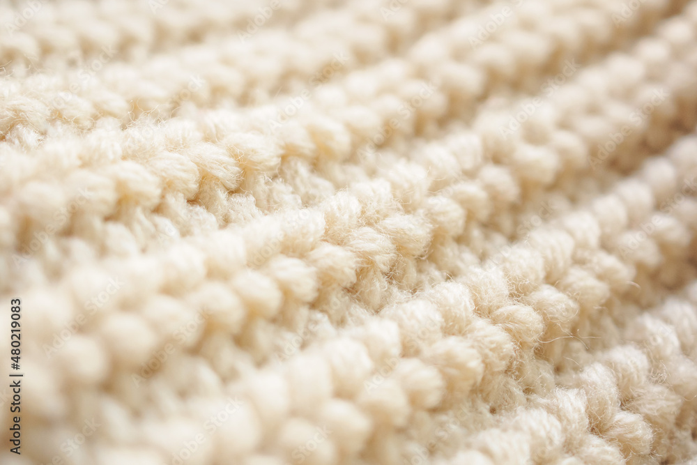 closeup beige knitted woolen fabric texture background closeup beige knitted woolen fabric texture background