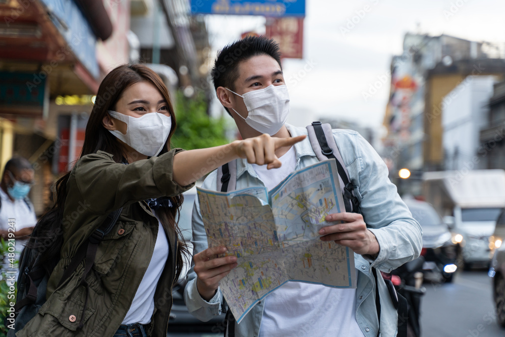 Asian romantic couple wear mask, travel in the city for honeymoon trip. 
