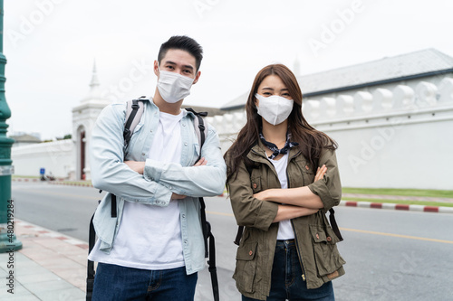 Portrait of Asian couple wear mask, travel in city for honeymoon trip. 