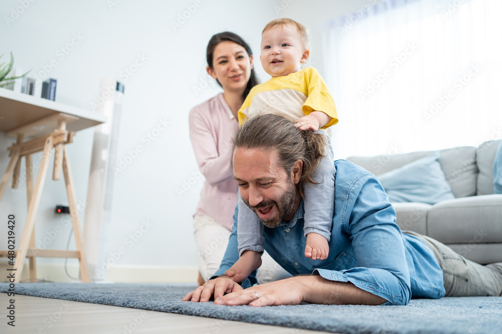 Caucasian happy loving parent play with baby toddler in living room. 