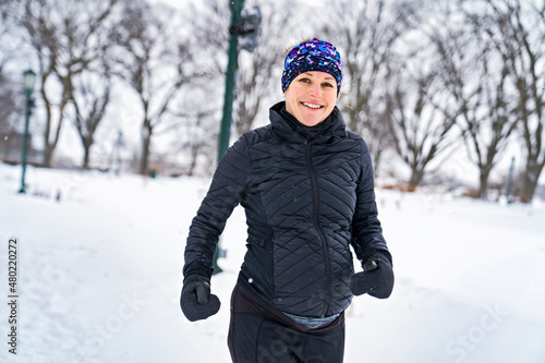 Nice Young Woman Running in Snowy Park © Louis-Photo