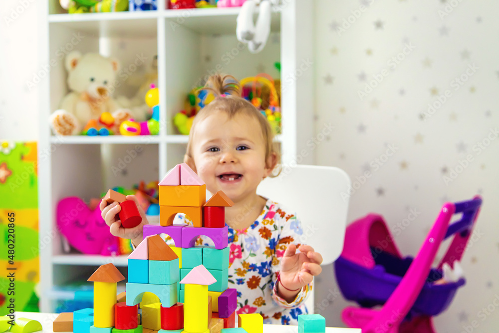 The child plays with toys in the room. Selective focus. The child plays with toys in the room. Selective focus.