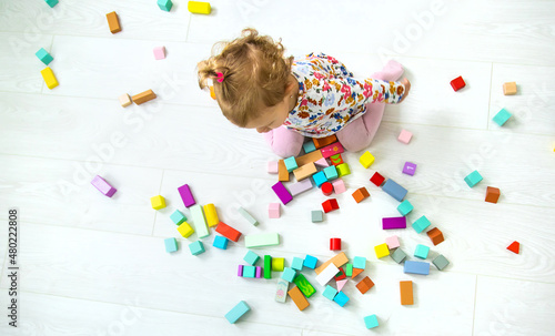 The child plays with toys in the room. Selective focus.