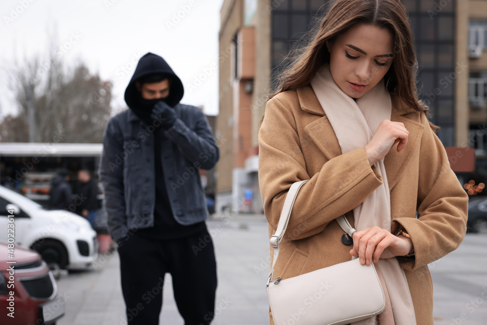 Man stalking young woman on city street Man stalking young woman on city street