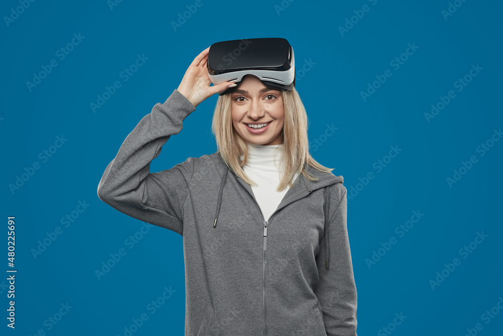 Smiling woman with VR headset looking at camera Smiling woman with VR headset looking at camera