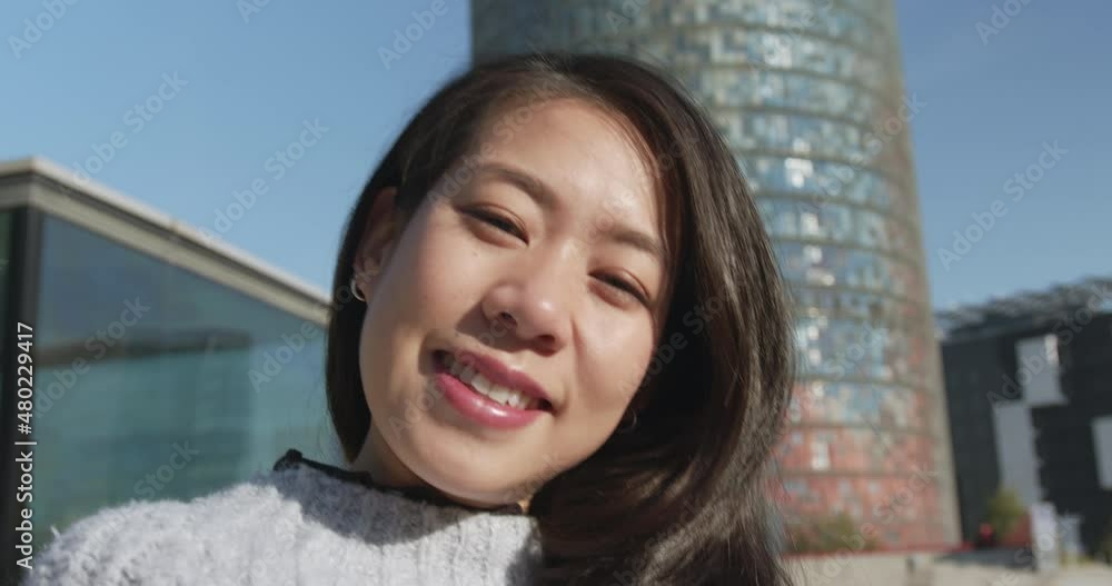 Portrait of smiling woman standing on street while text messaging on street with happiness Portrait of smiling woman standing on street while text messaging on street with happiness