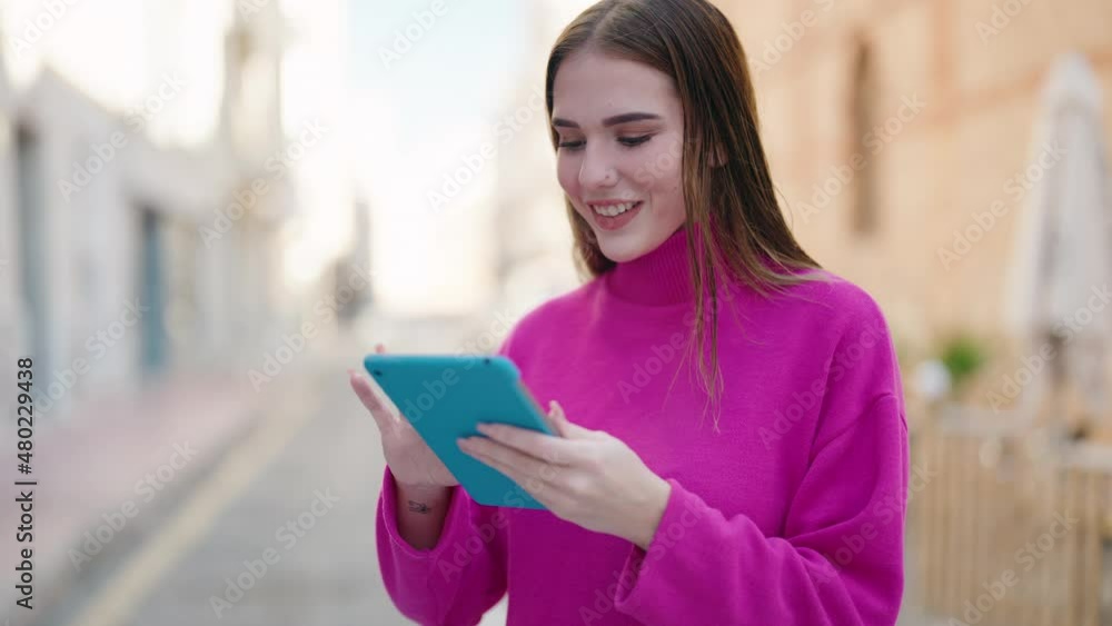 Young blonde woman smiling confident using touchpad at street Young blonde woman smiling confident using touchpad at street