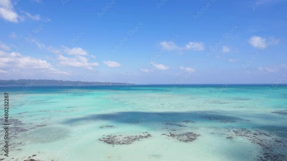 aerial drone take off shot from a beach looking out over the deepening blue green turquoise waters with the shadows of clouds over it in the tropical paradise of andaman havelock island malaysia aerial drone take off shot from a beach looking out over the deepening blue green turquoise waters with the shadows of clouds over it in the tropical paradise of andaman havelock island malaysia