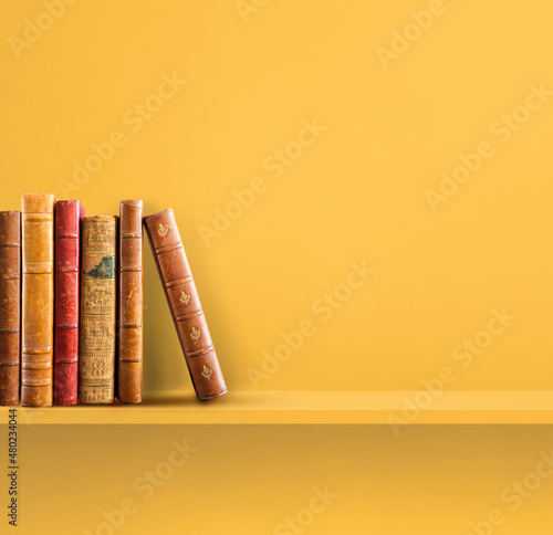 Papier peint bibliothèque - Papier peint Row of old books on yellow shelf. Square background