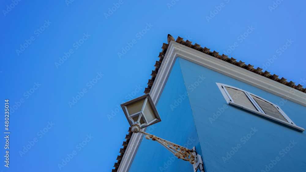 Casa azul con farola y cielo azul