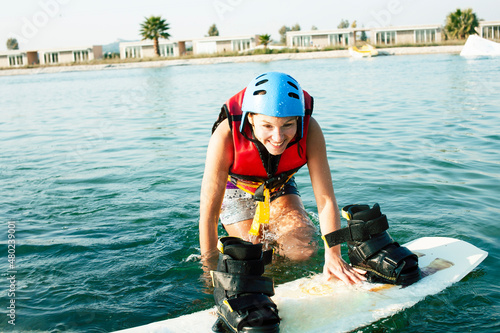 young smiling girl on wake board in water, happy lifestyle people on vacations photo