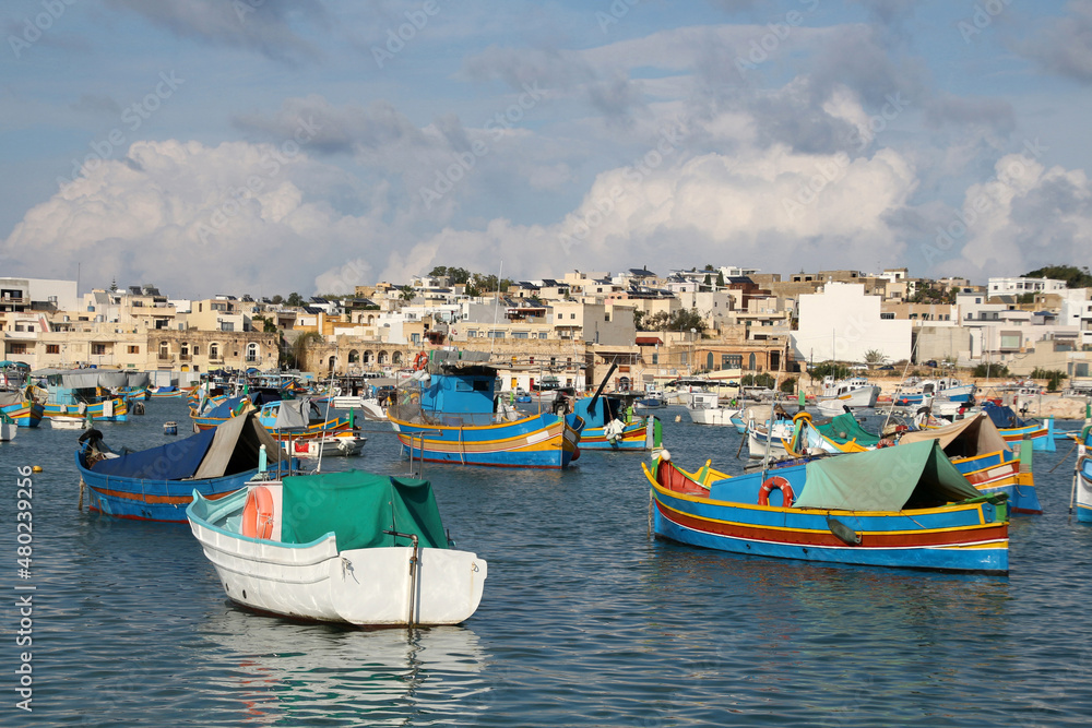 View of colorful fishing boats in Marsaxlokk harbor, Malta    